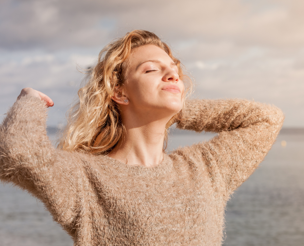 Vitamin D Beitragsbild: Frau mit hellem Pullover genießt die Sonne