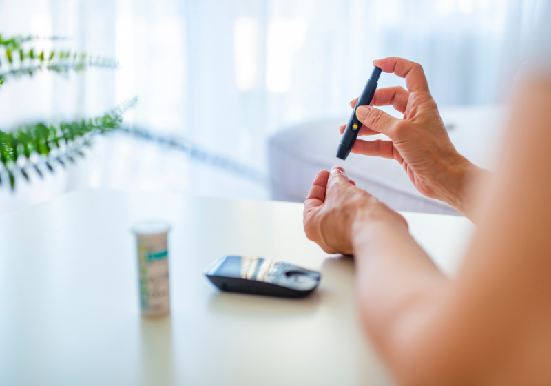 Zucker Krankheit Diabates: Frau nimmt sich Blut ab für Blutzuckerspiegel Test