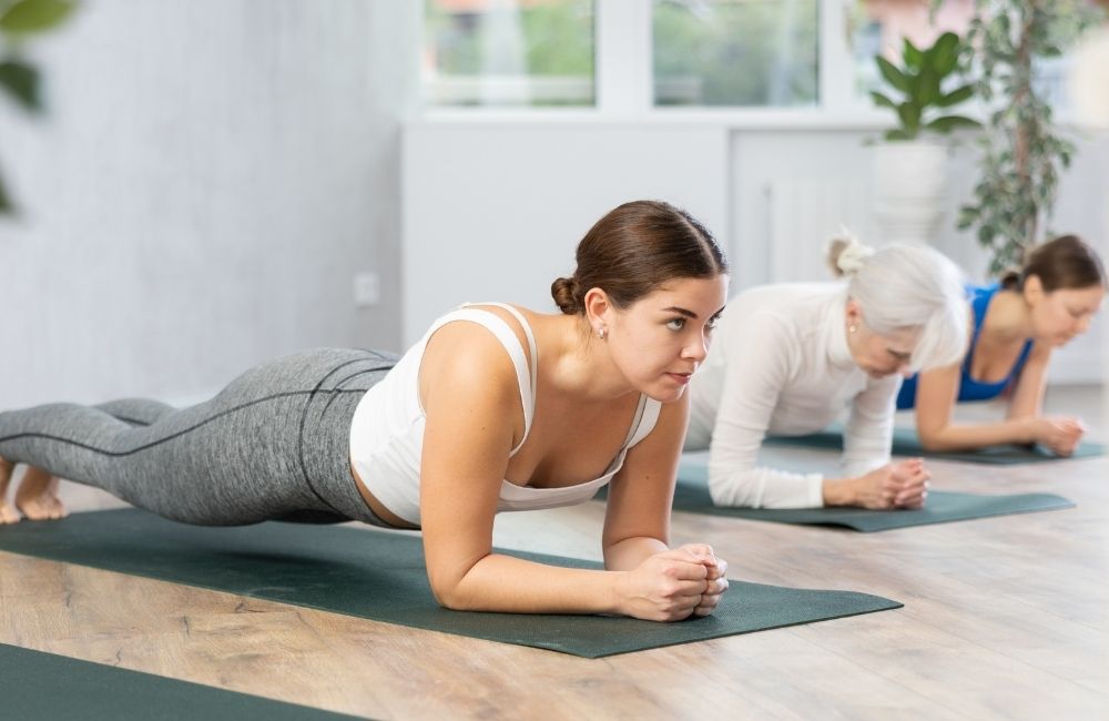 Warum Muskeln so wichtig sind Beitragsbild: Junge und alte Frau bei der Plank Übung im Sport