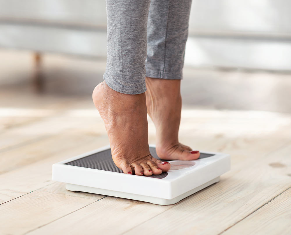 Gesund abnehmen beitragsbild: frau steht auf der waage