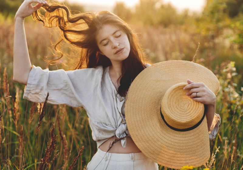 Frau mit Leinen Kleidung und Strohhut